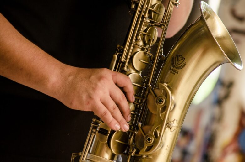person-in-black-shirt-playing-brass-colored-saxophone