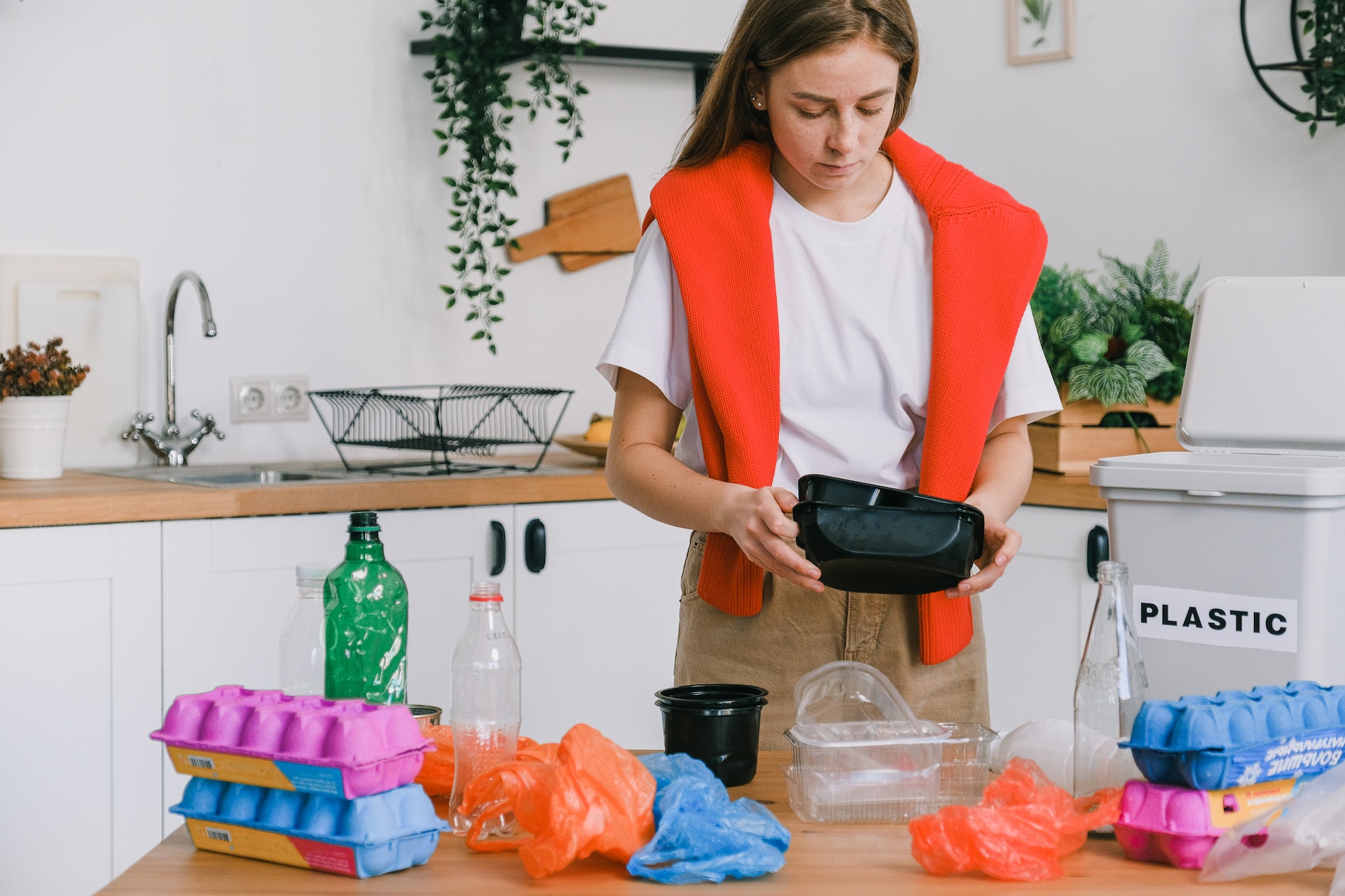 woman-sorting-trash-in-light-kitchen